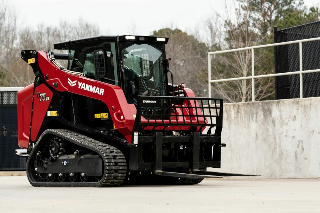 A Yanmar TL75VS Compact Track Loader Equipped with a Yanmar Pallet Fork Attachment