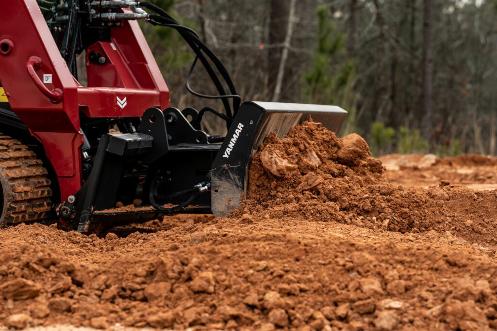 A Yanmar Compact Track Loader pushes dirt with a dozer blade