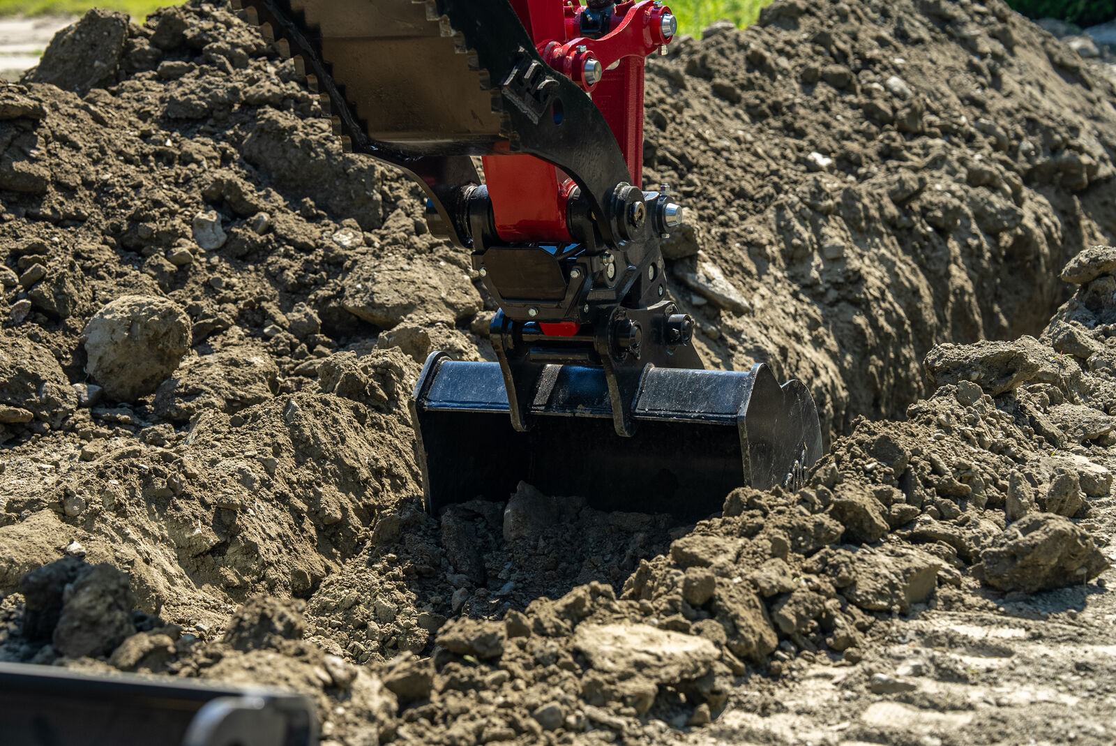 Yanmar ViO35-7 mini excavator bucket digging a hole with powerful precision.